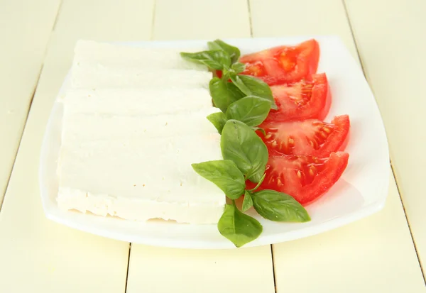 Schapen melk kaas, met basilicum en tomaat op een houten achtergrond kleur — Stockfoto
