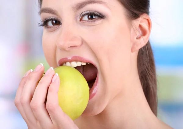 Woman with apple on bright background — Stock Photo, Image