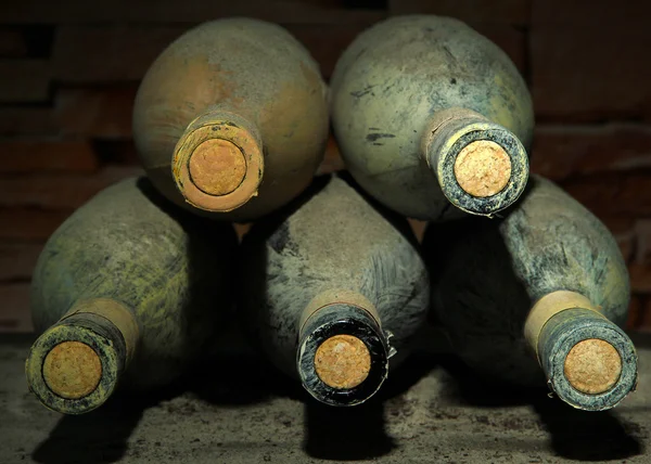 Viejas botellas de vino en bodega vieja, sobre fondo oscuro —  Fotos de Stock