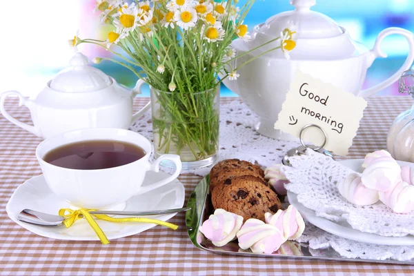 De instelling van de tabel met chamomiles op houten tafel op achtergrond van venster — Stockfoto