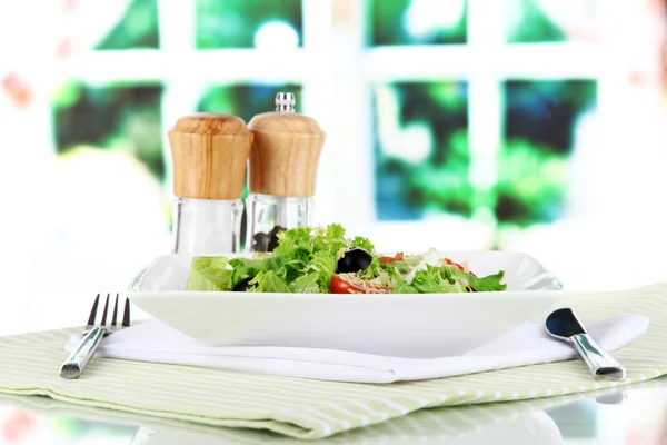 Leichter Salat auf Teller auf Serviette auf Fensterhintergrund — Stockfoto