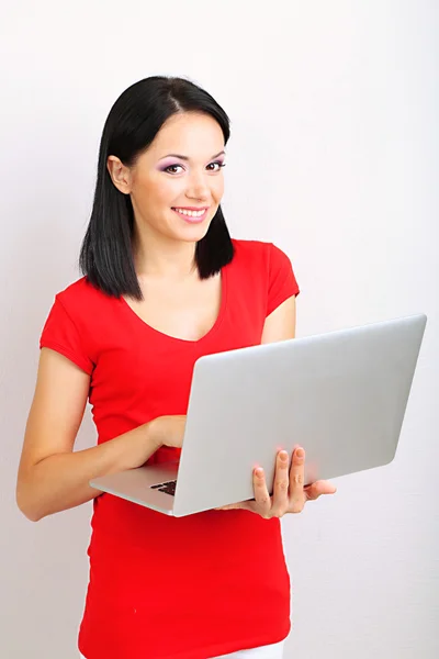 Mooie jonge vrouw met laptop in de kamer — Stockfoto