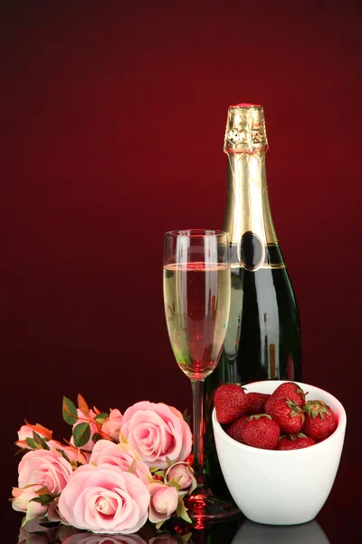 Romantic still life with champagne, strawberry and pink roses, on dark color background — Stock Photo, Image