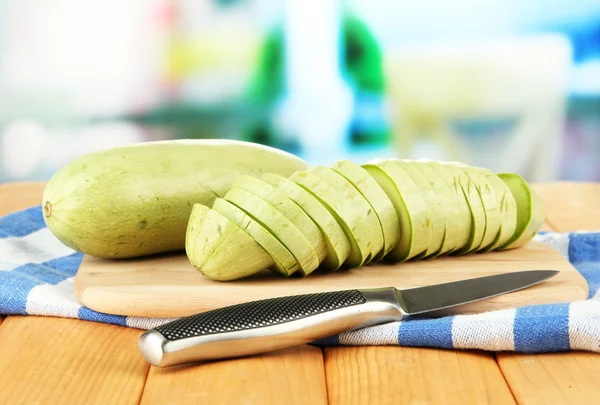 Fresh marrows on cutting board, on wooden table, on bright background — Stock Photo, Image