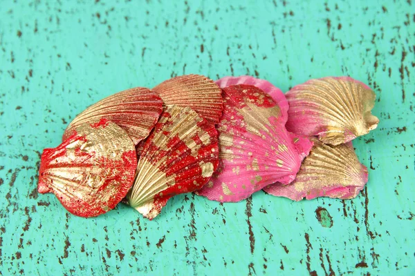 Bunte Muscheln auf farbigem Holzhintergrund — Stockfoto