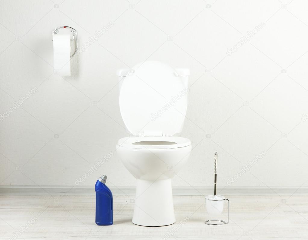 White toilet bowl and cleaner bottle in a bathroom