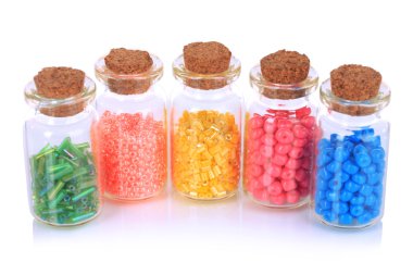 farklı renkli boncuklar üzerine beyaz izole şişelerde