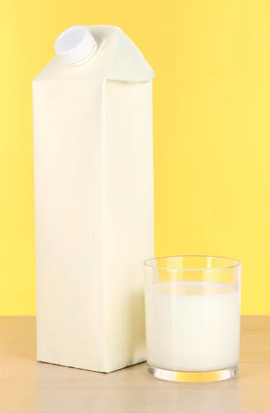 Milk pack on table on yellow background — Stock Photo, Image