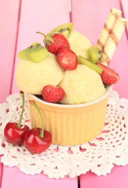 Delicious ice cream with fruits and berries in bowl on wooden table — Stock Photo, Image