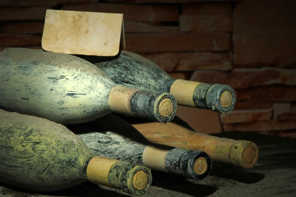 Vieilles bouteilles de vin dans une ancienne cave, sur fond sombre — Photo