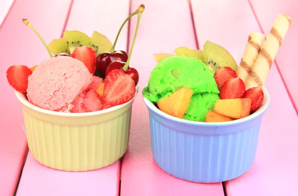 Leckeres Eis mit Früchten und Beeren in Schüssel auf Holztisch — Stockfoto