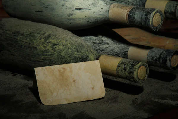 Vieilles bouteilles de vin dans une ancienne cave, sur fond sombre — Photo