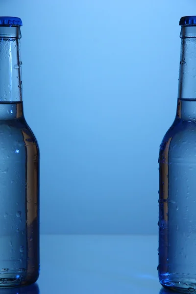 Water bottles on blue background — Stock Photo, Image