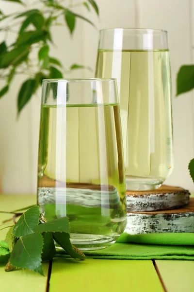 Glasses of birch sap on green wooden table — Stock Image Glasses of birch sap on green wooden table Royalty Free Stock Photos