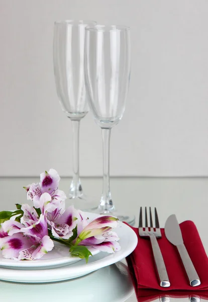 灰色の背景上に花とお祝いテーブルの設定 — ストック写真