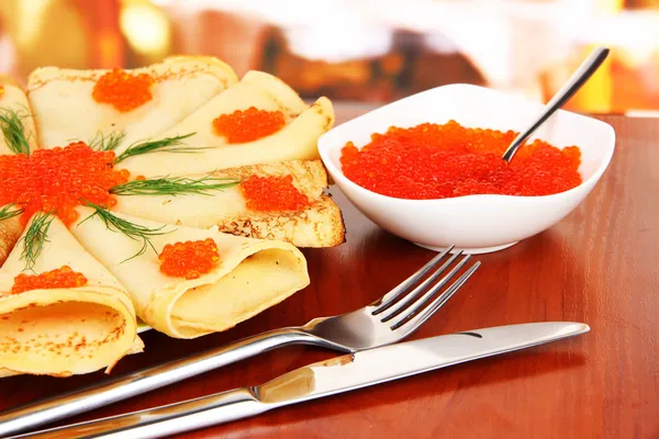 Läckra pannkakor med röd kaviar på bordet i café — Stockfoto