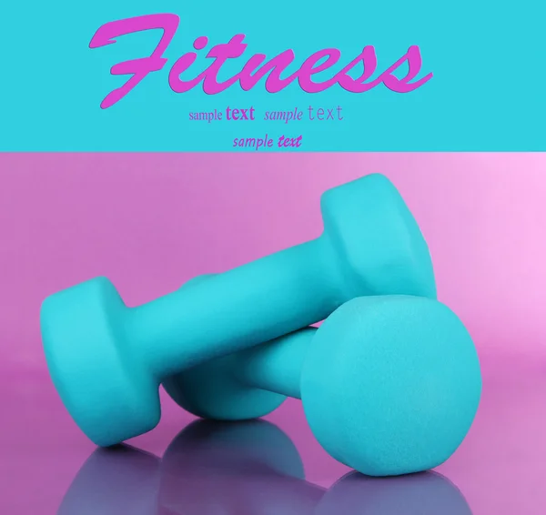 Dumbbells on purple background — Stock Photo, Image