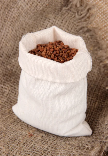 Grains in sack on wooden background — Stock Photo, Image