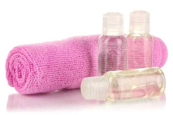 Hotel cosmetic bottles with towel isolated on white — Stock Photo, Image