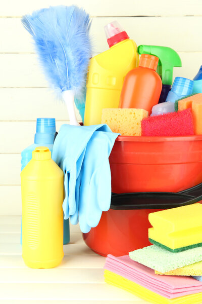 Cleaning items in bucket on white wooden background