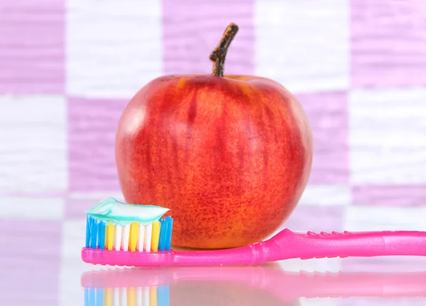Jabłko z szczoteczkę do zębów na półce w łazience — Zdjęcie stockowe