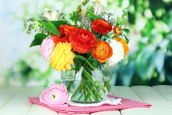 自然の背景に木製のテーブルの上のガラスの花瓶に優れたキンポウゲの花 — ストック写真