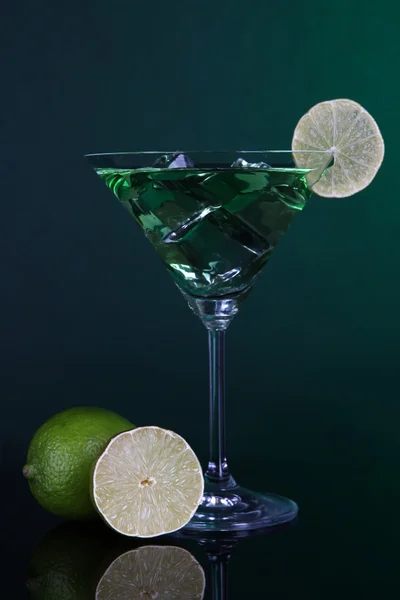 Grüner Cocktail mit Limette auf dunkelgrünem Hintergrund — Stockfoto