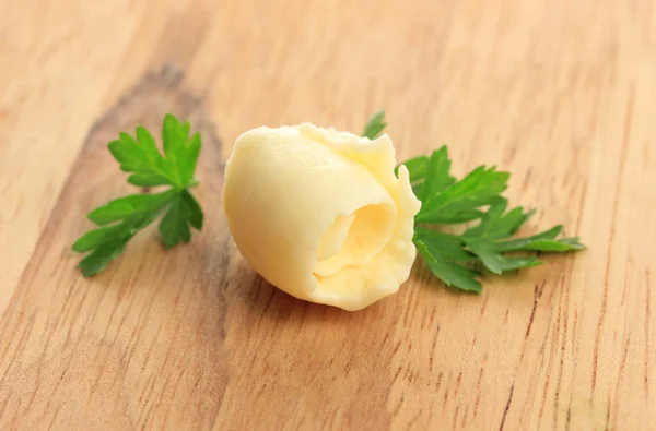 Butter curl on wooden table — Stock Photo, Image