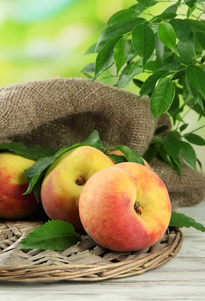 Pêches sucrées mûres sur table en bois dans le jardin, gros plan — Photo