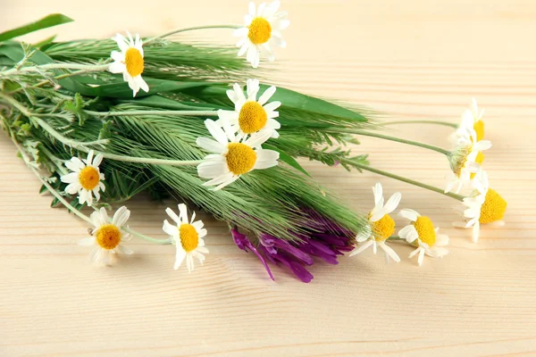 Wild flowers and green spikelets, on wooden background — Stock Photo, Image