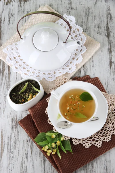 Чашка чая с липой на салфетках на деревянном столе — стоковое фото