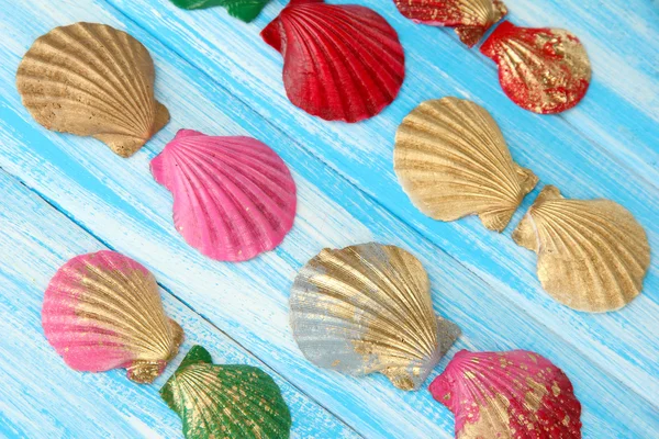 Conchas marinas de colores sobre fondo de madera de color — Foto de Stock