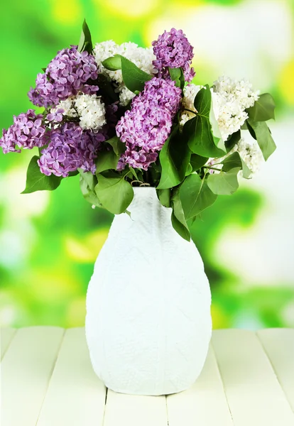 Hermosas flores lila, sobre mesa de madera sobre fondo brillante —  Fotos de Stock