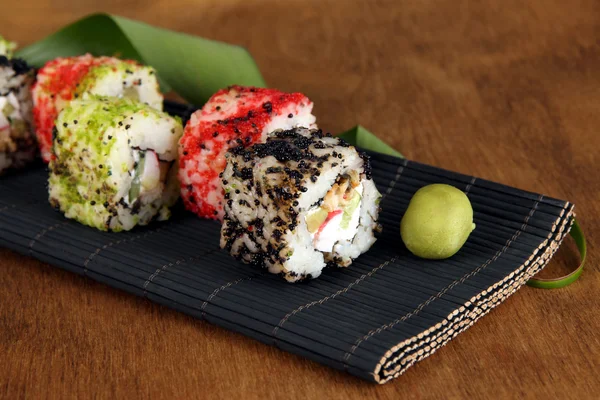 Lezzetli maki sushi - mat kahverengi zemin üzerinde rulo — Stok fotoğraf