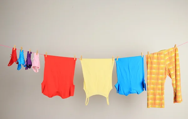 Laundry line with clothes on wall background — Stock Photo, Image