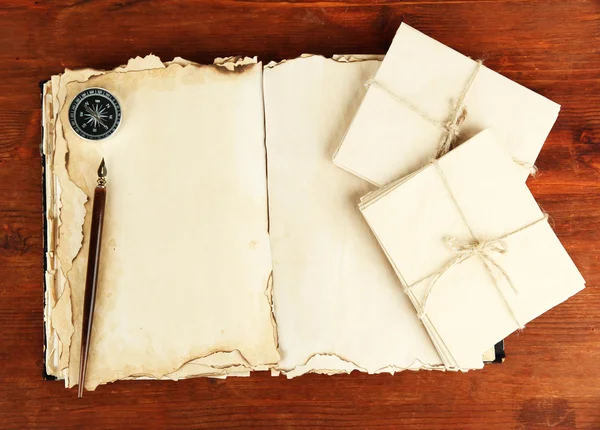 Open old book, letters and compass on wooden background — Stock Photo, Image