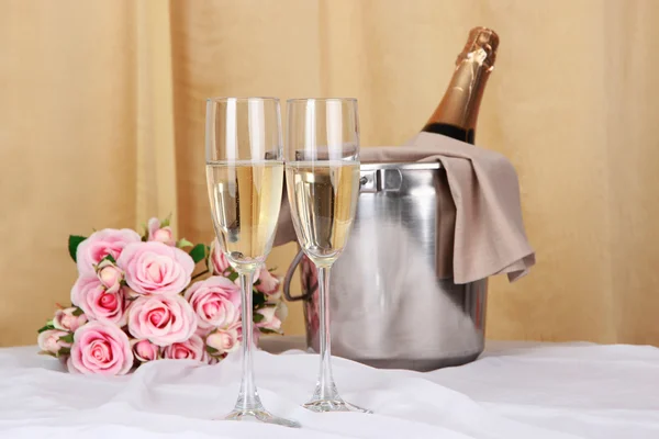 Champagne en bril op ronde tafel op doek achtergrond — Stockfoto