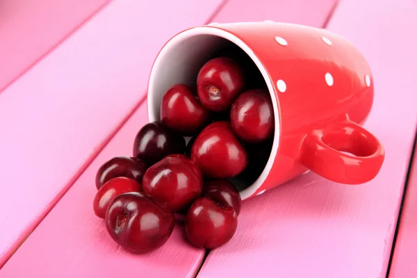 Kirschbeeren im Becher auf Holztisch in Großaufnahme — Stockfoto