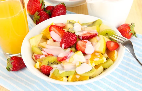 Полезный фруктовый салат из свежих фруктов и ягод в миске на салфетке на деревянном столе крупным планом — стоковое фото