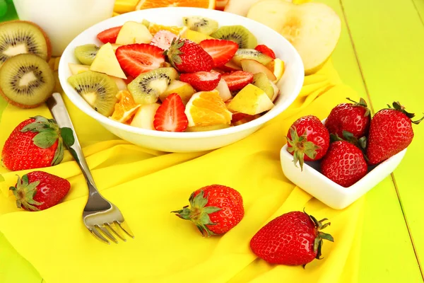 Useful fruit salad of fresh fruits and berries in bowl on tablecloth close-up — Stock Photo, Image