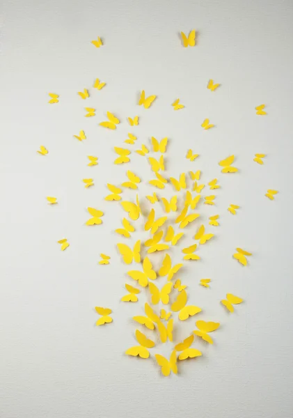 Papper gula fjärilar flyga på väggen i olika riktningar — Stockfoto