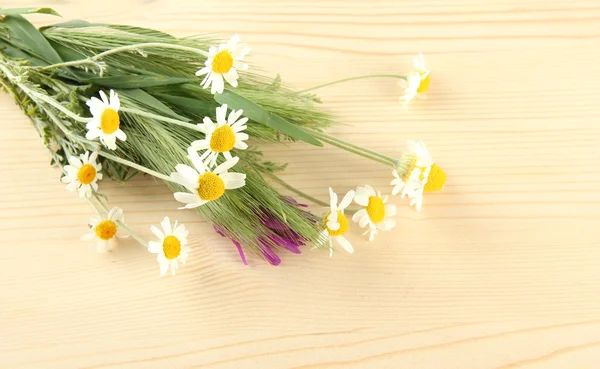 Wild flowers and green spikelets, on wooden background — Stock Photo, Image