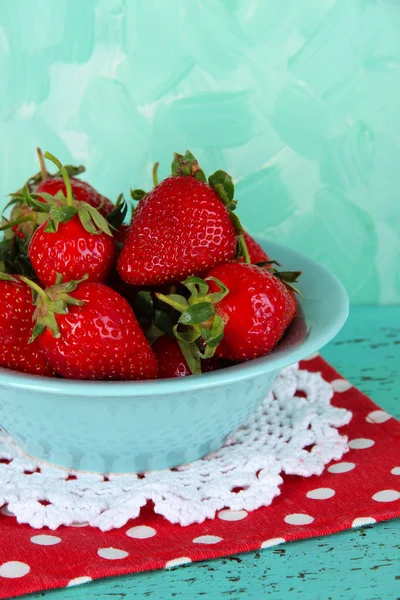 Fresas en plato sobre servilleta sobre fondo azul — Foto de Stock