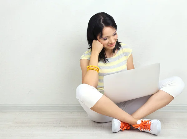 Hermosa joven sentada con cuaderno en la habitación — Foto de Stock