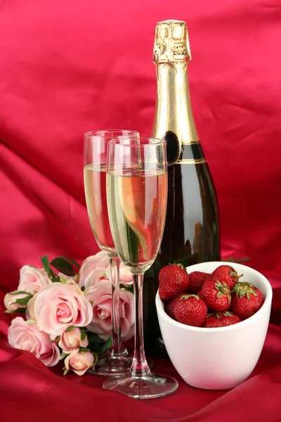 Natura morta romantica con champagne, fragole e rose rosa, su sfondo tessuto a colori — Foto Stock