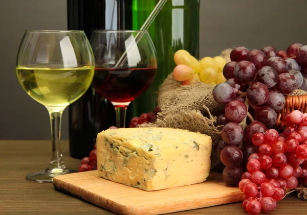 Şarap, mavi peynir ve gri arka plan üzerinde ahşap masa üstünde üzüm ile kompozisyon — Stok fotoğraf