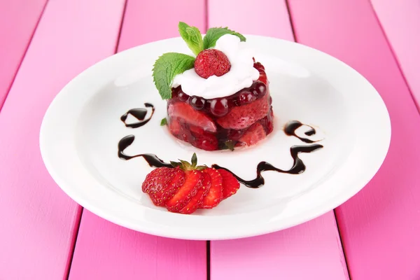 Leckeres Gelee-Dessert mit frischen Beeren, auf farbigem Holzhintergrund — Stockfoto