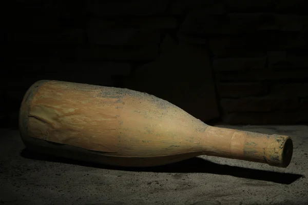 Vieille bouteille de vin dans une ancienne cave, sur fond sombre — Photo