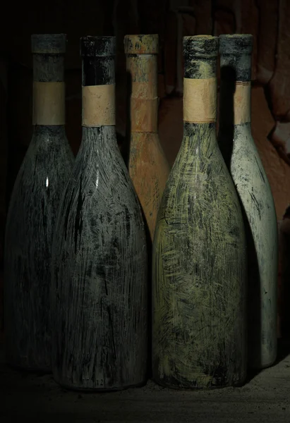 Old bottles of wine in old cellar, on dark background — Stock Photo, Image