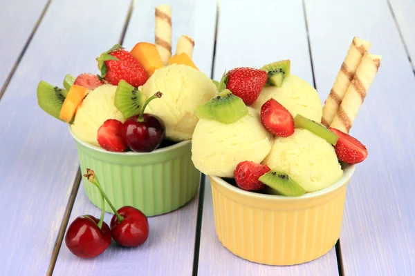 Finom fagylalt, gyümölcsök és bogyók tálba a fából készült asztal — Stock Fotó